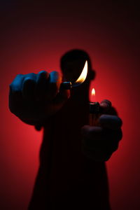 Close-up of hand holding lit candle