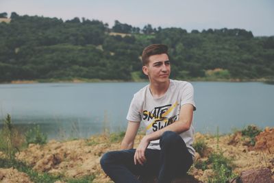 Portrait of young man sitting on land