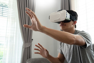 Man wearing virtual reality simulator at home