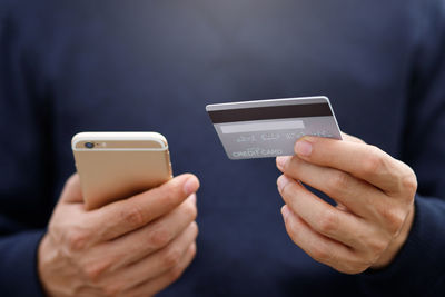 Midsection of man using mobile phone