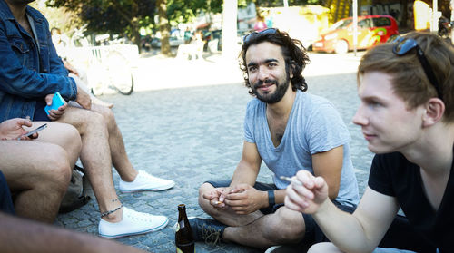 Friends discussing while sitting on street