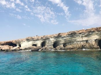 Rock formations by sea against sky