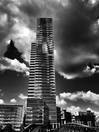 Low angle view of skyscrapers against cloudy sky