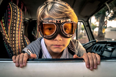 Portrait of boy wearing protective eyewear while sitting in travel trailer