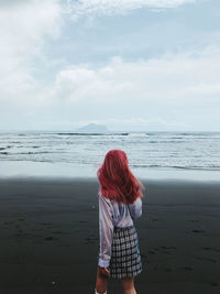 Rear view of woman standing on beach