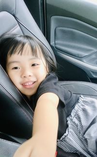 Portrait of smiling girl sitting in car