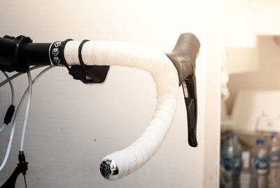 Close-up of bicycle handlebar against white wall