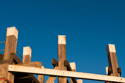 Low angle view of wooden structure against blue sky