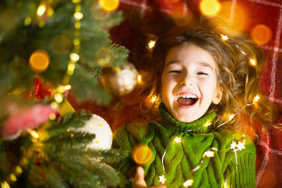 Portrait of smiling girl against christmas decoration