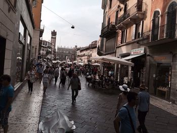 People walking on street amidst buildings in city