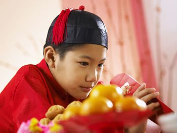 Close-up of teenage boy in traditional clothes looking in envelope