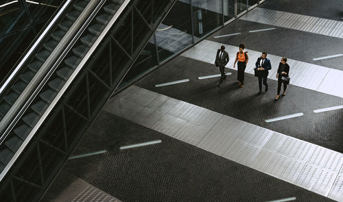 High angle view of male entrepreneurs discussing with female colleagues on walkway