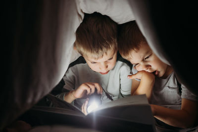 Side view of boy looking away while lying on bed at home