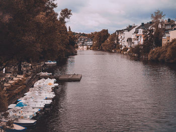 River amidst buildings in city against sky