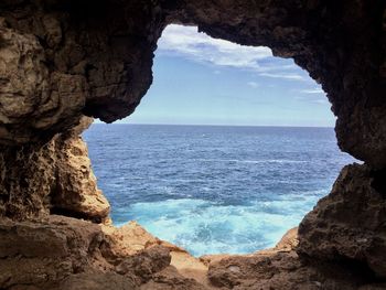 Scenic view of rock formation in sea against sky