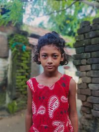 Portrait of girl standing against brick wall