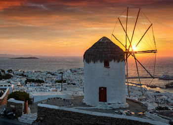 Traditional windmill against sky during sunset