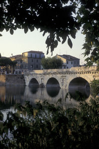 Arch bridge over river against buildings