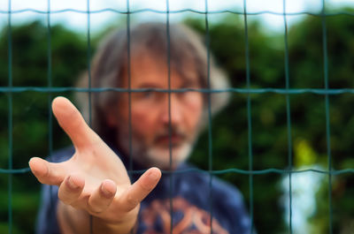 Portrait of man hand on mirror against blurred background