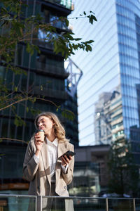 Young woman using mobile phone in city