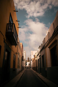 Narrow street amidst buildings against sky