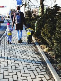 Father and son walking on sidewalk