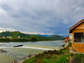 Scenic view of lake by buildings against sky