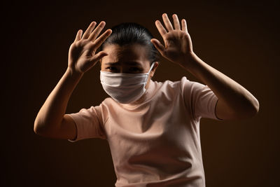 Portrait of man wearing mask against black background