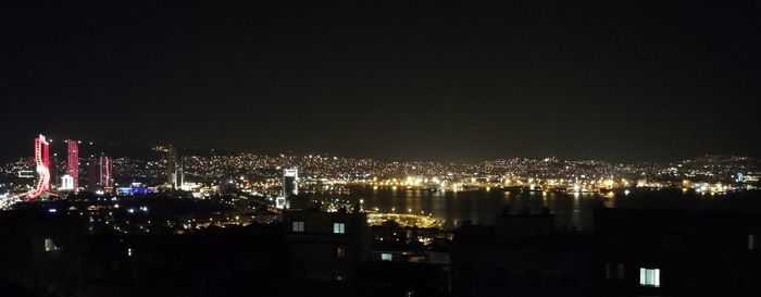 Illuminated cityscape against sky at night