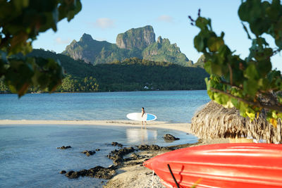 Mid distance view of man with surfboard walking at beach