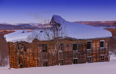 The old ugly dilapidated wooden house on the sunset