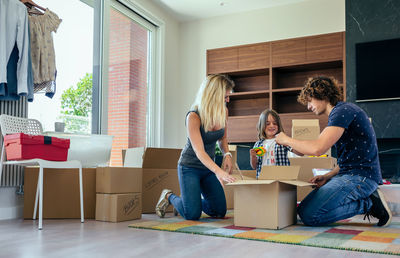 Parents with son unpacking boxes at home