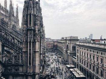 People at town square by duomo di milano against sky