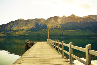 Pier over lake against mountains