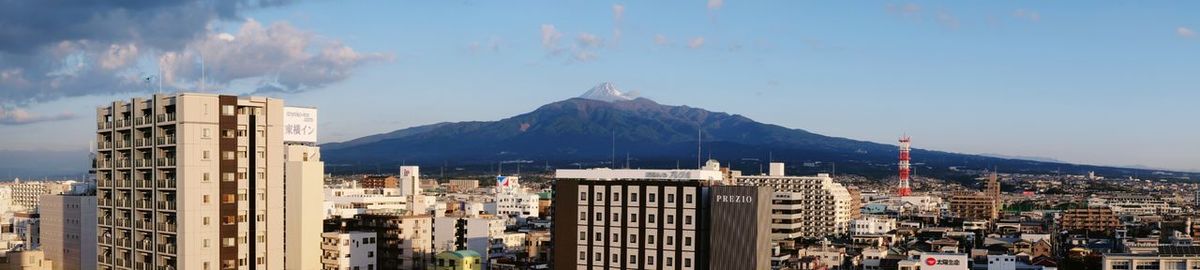 Panoramic view of buildings in city against sky