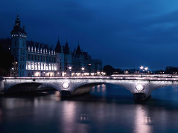 Bridge over river in city at night