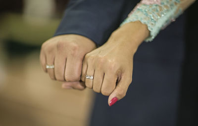 Cropped hands of bride and bridegroom showing wedding rings