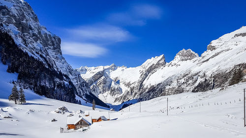 Scenic view of snowcapped mountains against blue sky