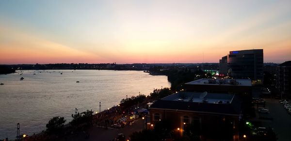 High angle view of city by sea against sky during sunset