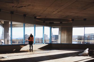 Rear view of woman standing on bridge