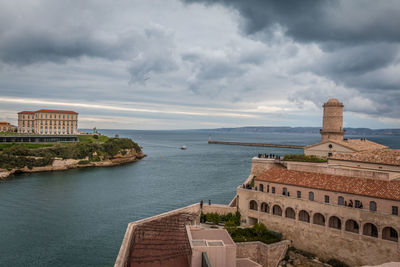 Buildings in city against cloudy sky