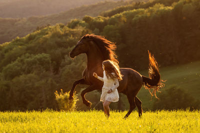 Woman running with horse on land