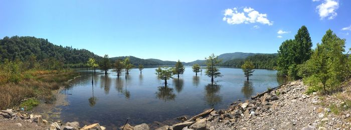 Scenic view of lake and mountains against clear blue sky