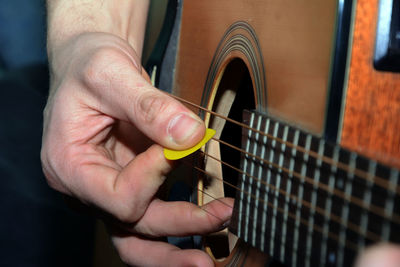 Midsection of man playing guitar