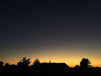 Low angle view of silhouette trees against clear sky