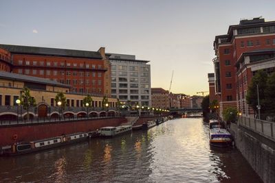 Canal amidst buildings against sky in city