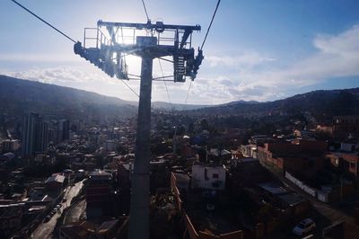 Overhead cable cars in city against sky