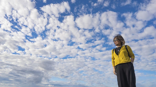 Rear view of woman standing against sky