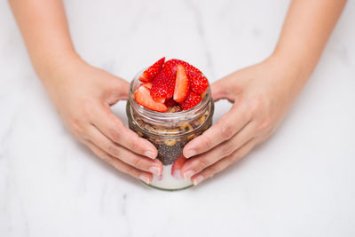 Midsection of woman holding strawberry