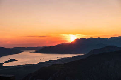 Scenic view of silhouette mountains against romantic sky at sunset